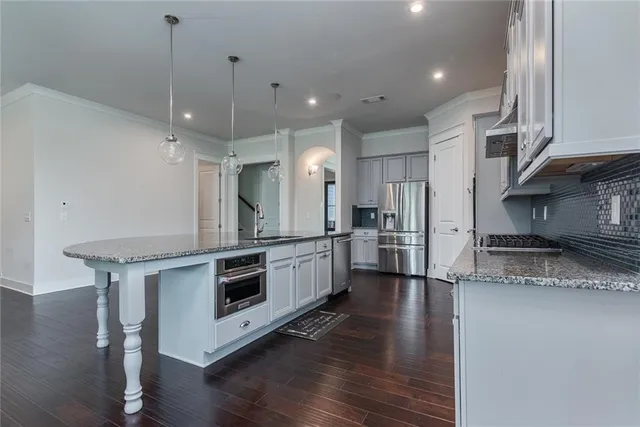 a kitchen with stainless steel appliances granite countertop a stove a sink and a refrigerator