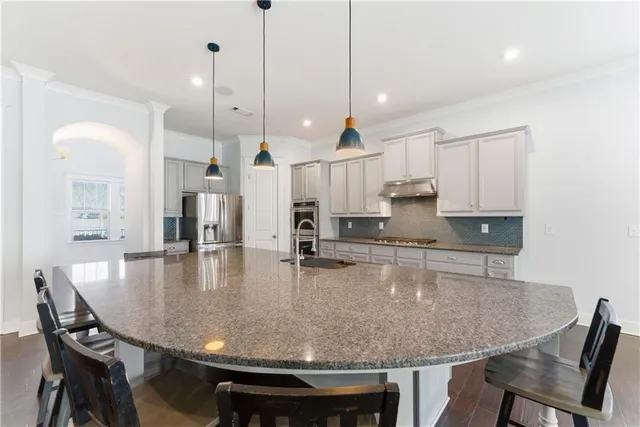 a large kitchen with kitchen island a table and chairs