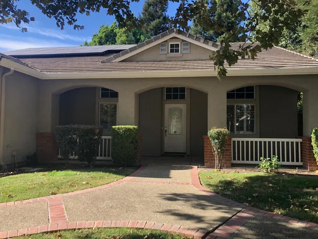 a view of a house with a small yard and wooden fence