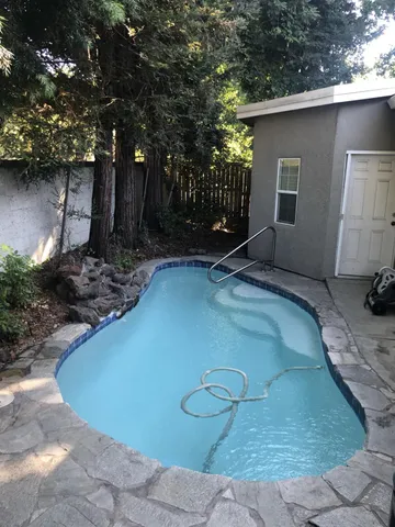 a view of a backyard with floor to ceiling window and plants