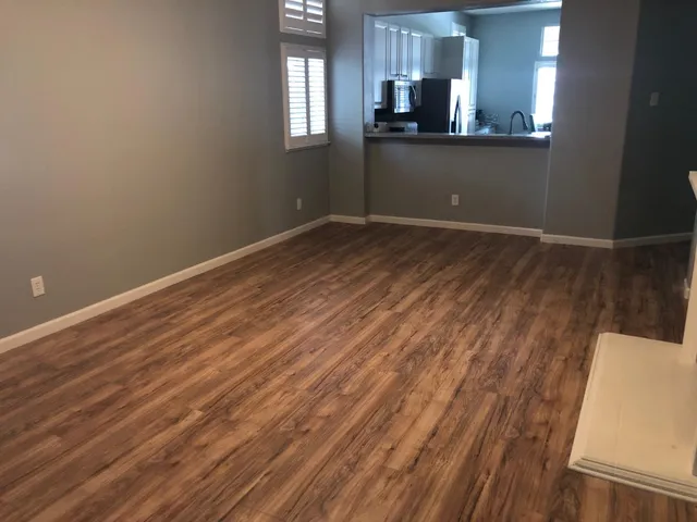 a view of a kitchen with wooden floor and a window
