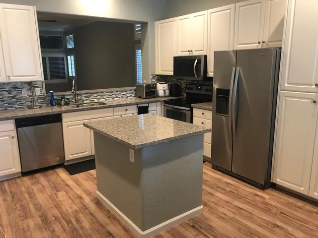 a kitchen with stainless steel appliances granite countertop a refrigerator stove and sink