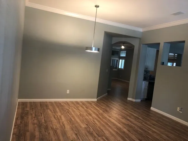 a view of a room with wooden floor and a ceiling fan
