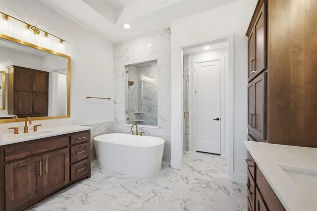a spacious bathroom with a double vanity sink mirror and bathtub