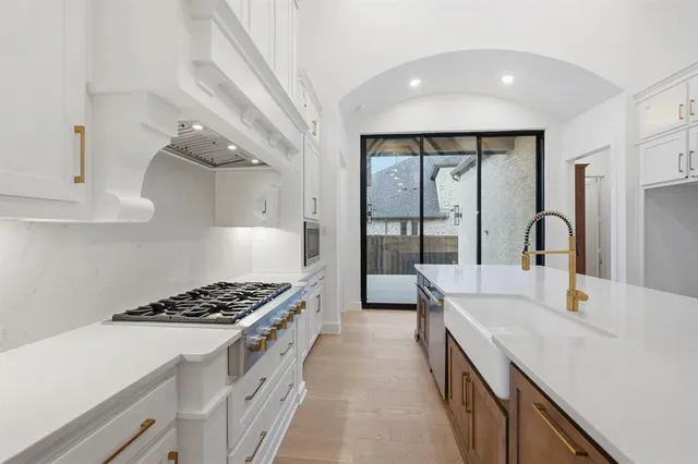 a kitchen with stainless steel appliances granite countertop a sink stove and cabinets