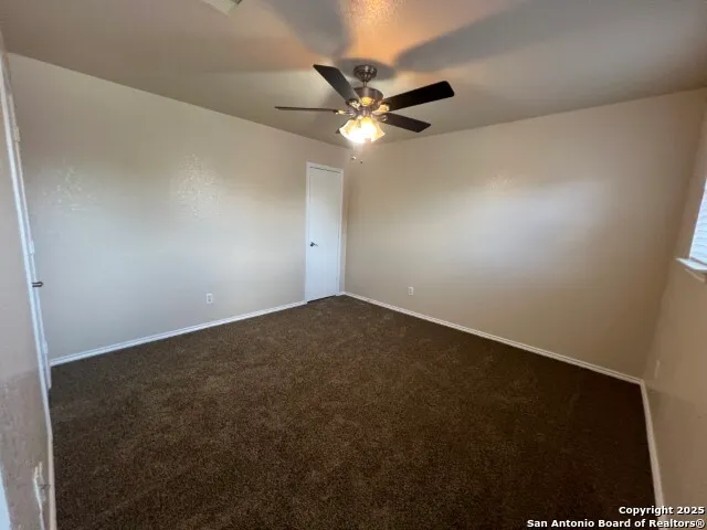 an empty room with a window and a fan