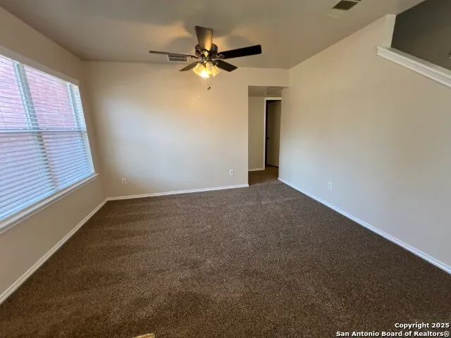 a view of a livingroom with a ceiling fan and window