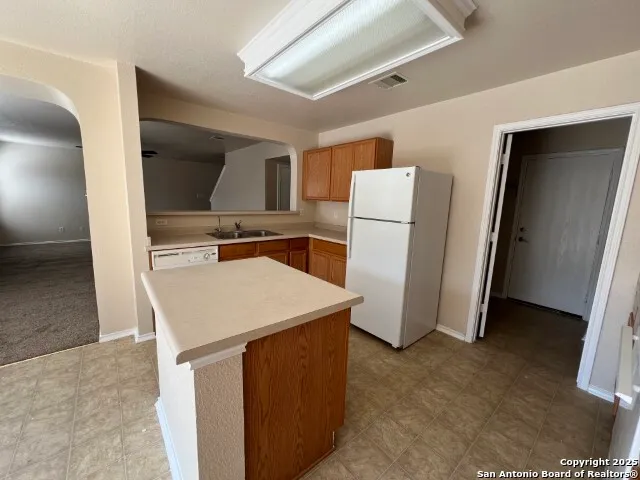 a kitchen with a refrigerator sink and stove