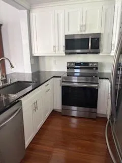 a kitchen with granite countertop a stove and a microwave