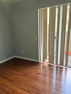 a view of a room with wooden floor and a window