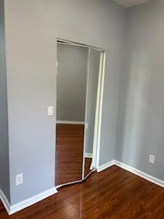 a view of an empty room with wooden floor
