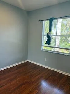 a view of a small space with wooden floor and a window