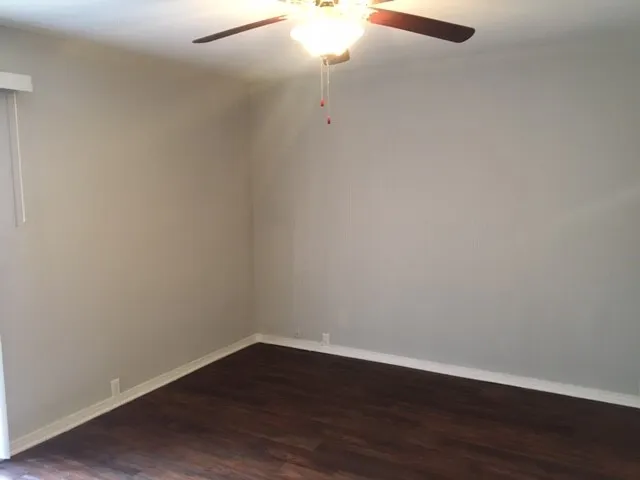 a view of a small space with wooden floor and fan