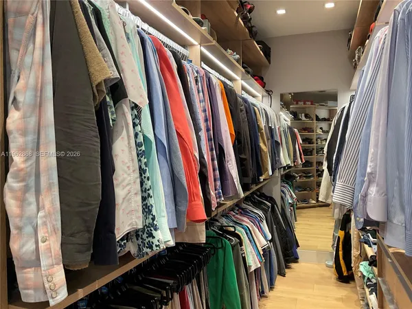 a view of walk in closet with clothes and shoes
