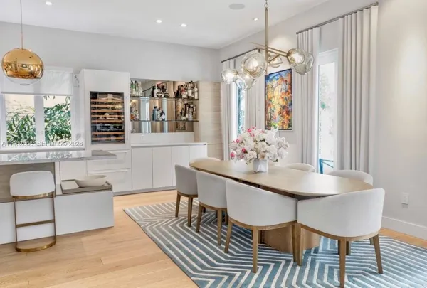 a dining room with furniture a chandelier and wooden floor