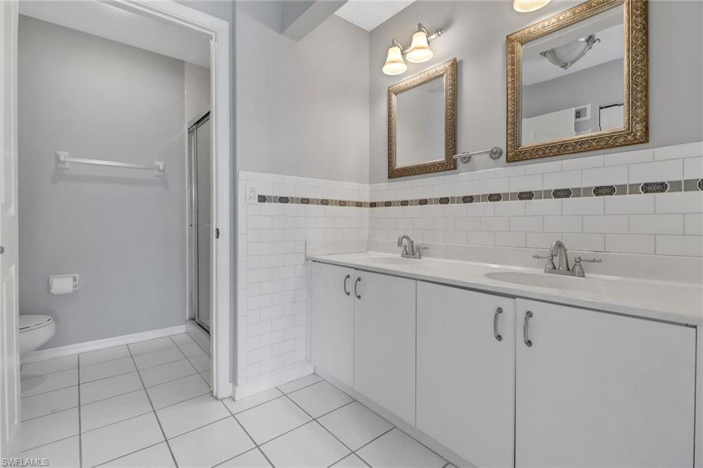 875 New Waterford Drive, Unit T201 Naples, FL 34104 - Photo 12 of 25 a bathroom with a sink a toilet and mirror