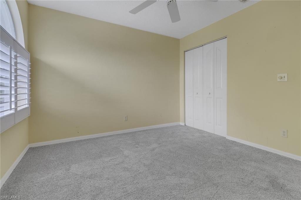 875 New Waterford Drive, Unit T201 Naples, FL 34104 - Photo 14 of 25 an empty room with a window and a ceiling fan