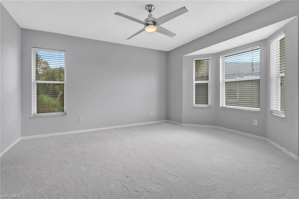875 New Waterford Drive, Unit T201 Naples, FL 34104 - Photo 10 of 25 an empty room with a window and a ceiling fan