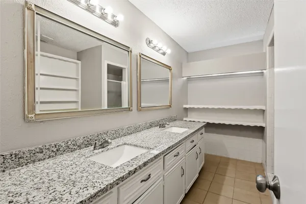 a bathroom with a granite countertop sink a mirror and a bathtub