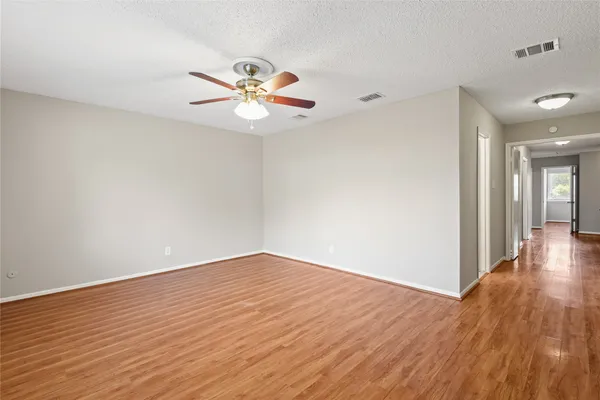 a view of an empty room with wooden floor