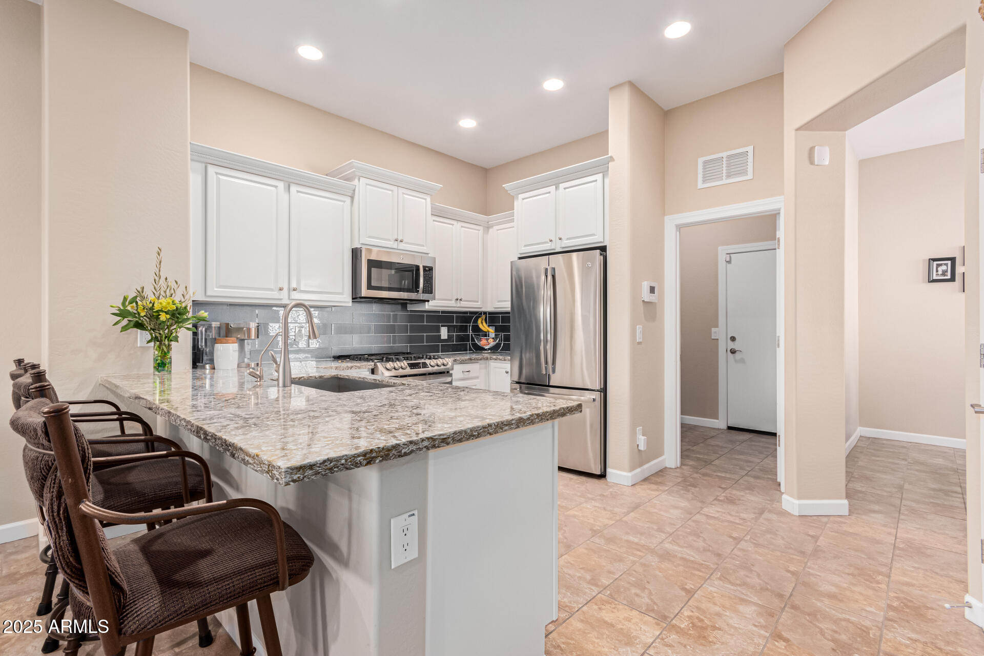 4777 South Fulton Ranch Boulevard, Unit 1027 Chandler, AZ 85248 - Photo 14 of 50 a kitchen with stainless steel appliances granite countertop a stove refrigerator sink and cabinets