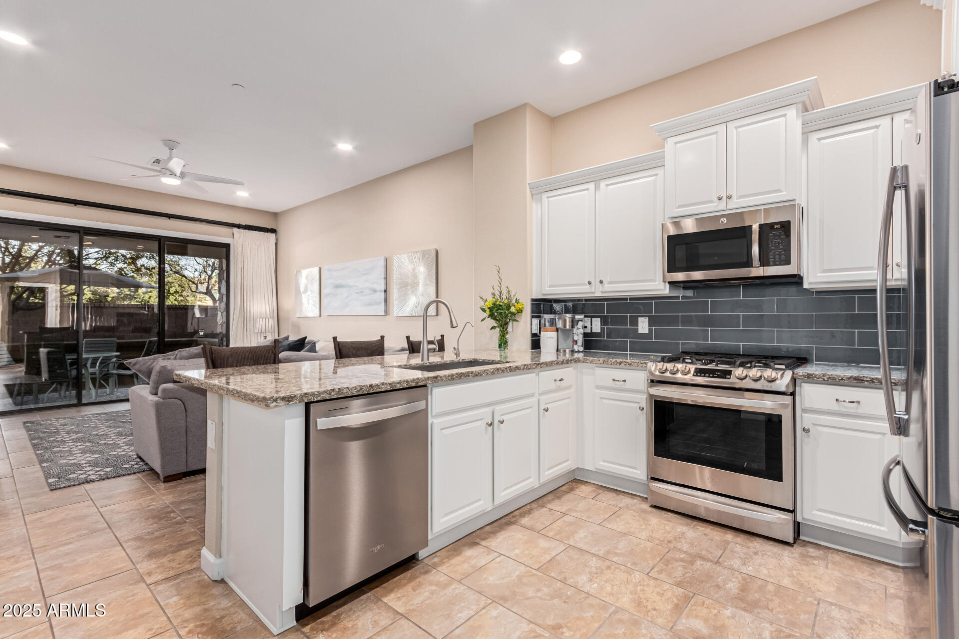 4777 South Fulton Ranch Boulevard, Unit 1027 Chandler, AZ 85248 - Photo 15 of 50 a kitchen with stainless steel appliances granite countertop a stove a sink and a microwave