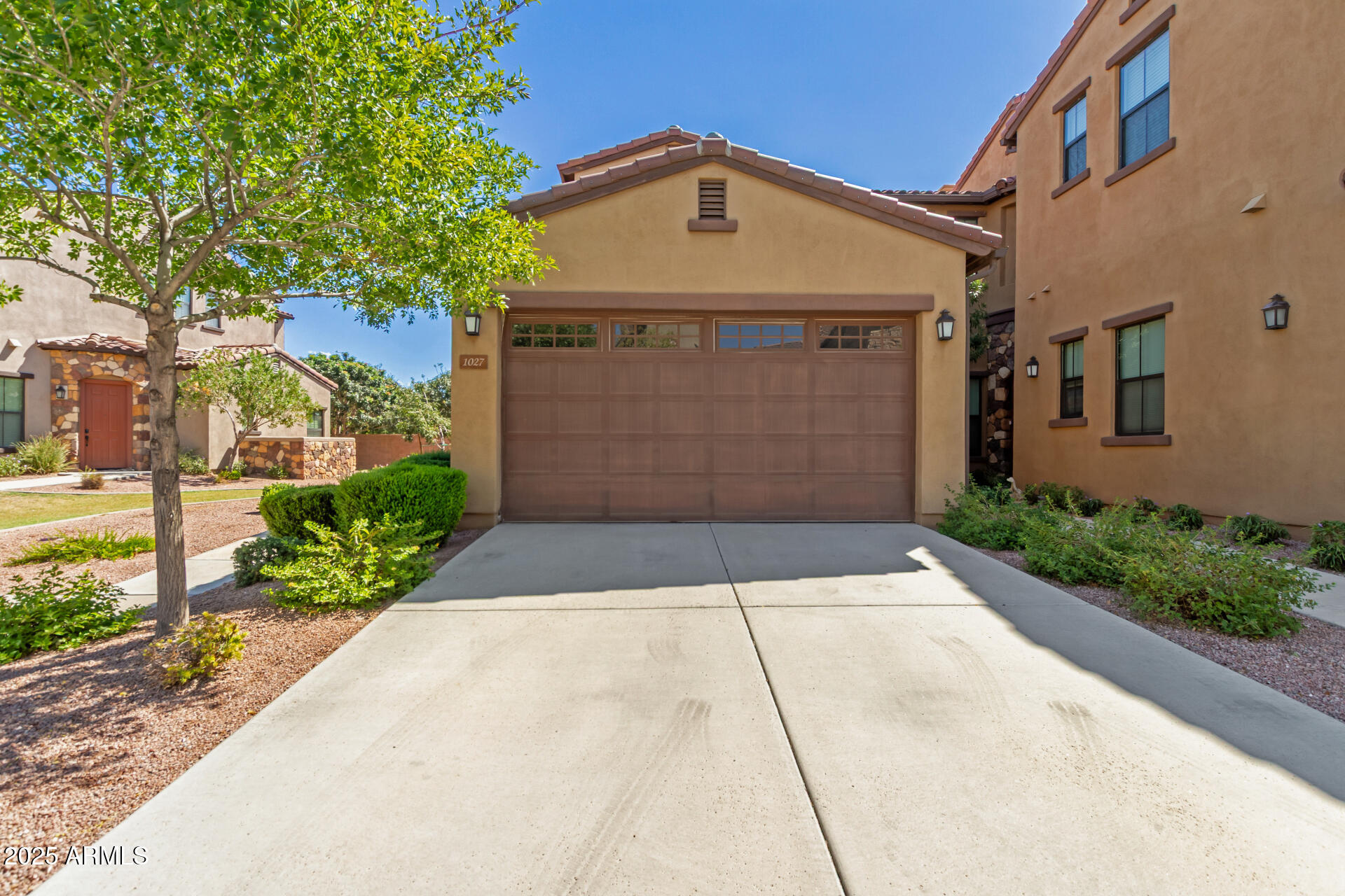 4777 South Fulton Ranch Boulevard, Unit 1027 Chandler, AZ 85248 - Photo 2 of 50 a front view of a house with a yard and garage