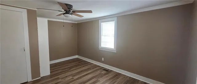 a view of a room with wooden floor and a ceiling fan