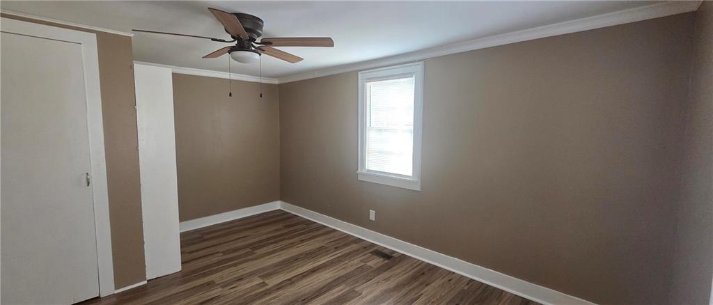 7043 South Goddard Road Stonecrest, GA 30038 - Photo 16 of 33 a view of a room with wooden floor and a ceiling fan
