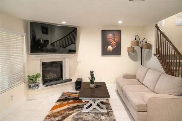 a living room with furniture a flat screen tv and a fireplace