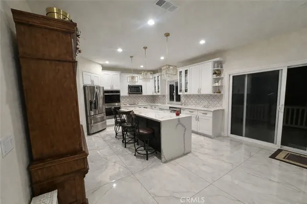 a kitchen with stainless steel appliances granite countertop a refrigerator sink and microwave