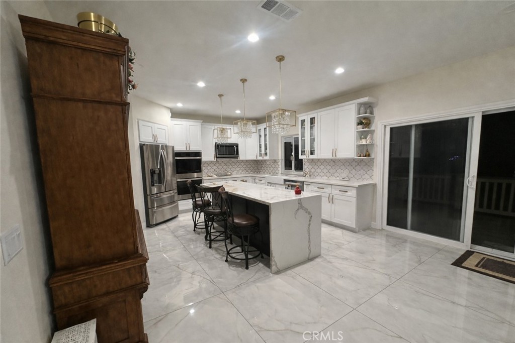14464 Dove Canyon Drive Riverside, CA 92503 - Photo 10 of 25 a kitchen with stainless steel appliances granite countertop a refrigerator sink and microwave