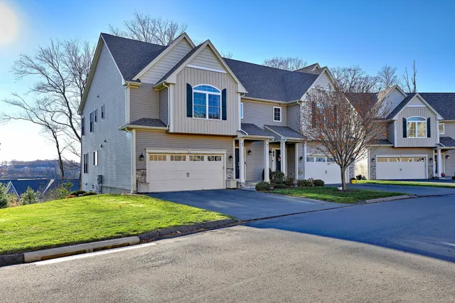 a view of a big house with a big yard and large trees