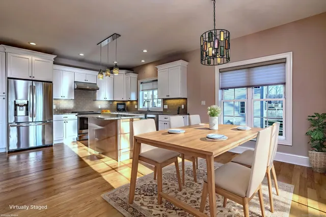 a view of a dining room and livingroom with furniture wooden floor a chandelier