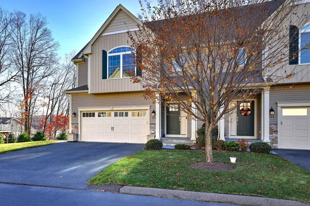 a front view of a house with a garden and trees