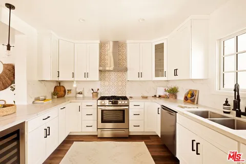 a kitchen with granite countertop a sink stainless steel appliances and cabinets