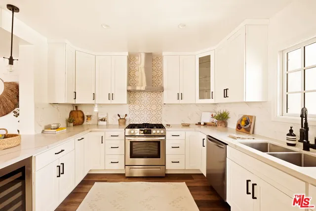 a kitchen with granite countertop a sink stainless steel appliances and cabinets