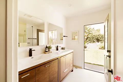 a bathroom with a sink a mirror a vanity and shower
