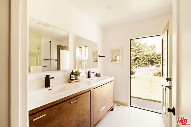 a bathroom with a sink a mirror a vanity and shower