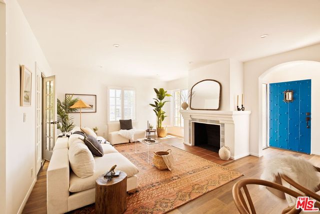 a living room with furniture a fireplace and potted plants