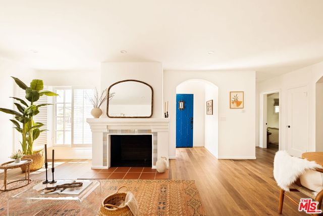 a living room with furniture a fireplace and a potted plant