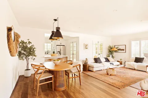 a living room with furniture a chandelier and a dining table