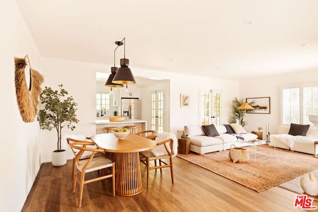 a living room with furniture a chandelier and a dining table