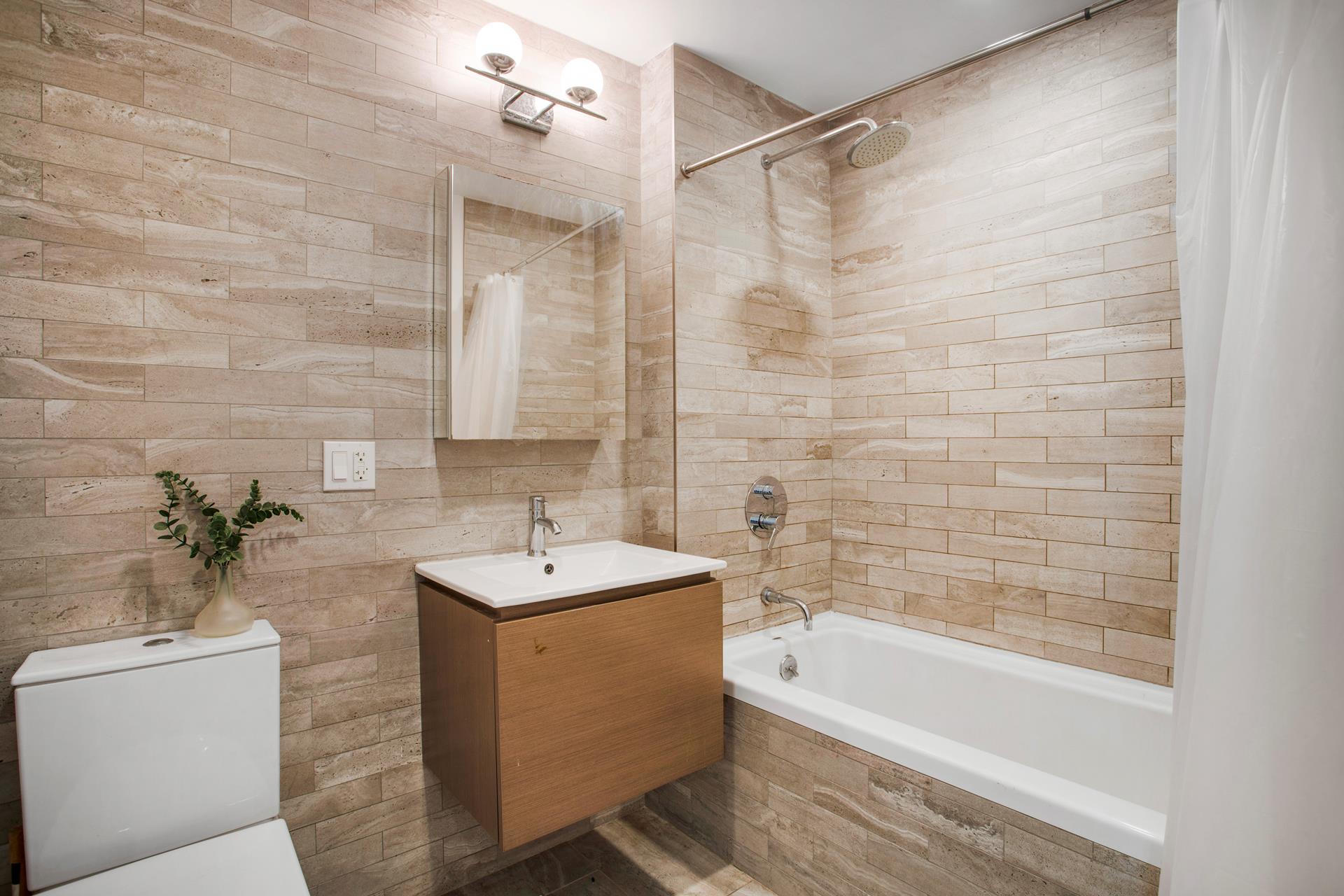 686 MacDonough Street, Unit 3A Brooklyn, NY 11233 - Photo 4 of 7 a bathroom with a sink a bathtub and a shower