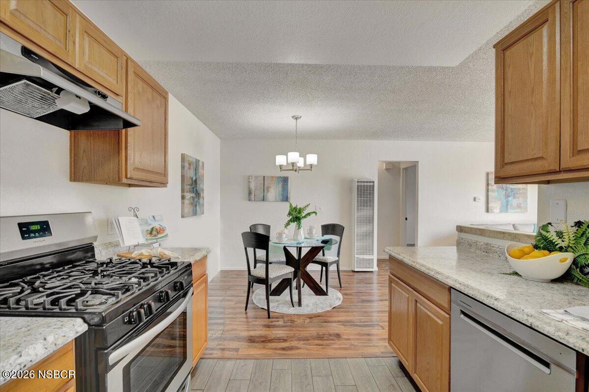 3400 Santa Maria Way, Unit 207B Santa Maria, CA 93455 - Photo 23 of 50 a kitchen with stainless steel appliances granite countertop a stove a sink dishwasher and cabinets with wooden floor