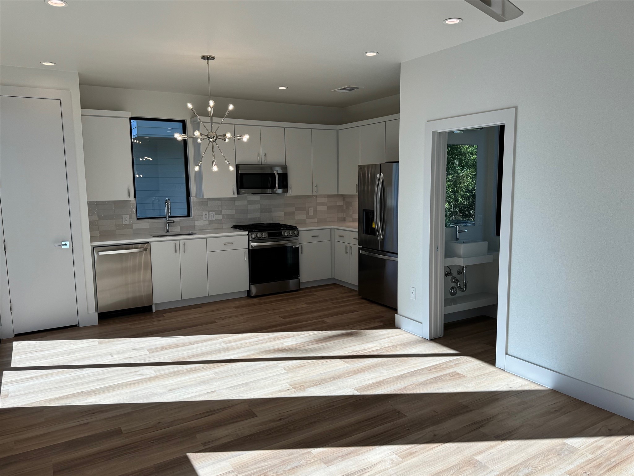 1131 Walton Lane, Unit 6 Austin, TX 78721 - Photo 3 of 16 a kitchen with stainless steel appliances kitchen island granite countertop a refrigerator and a sink