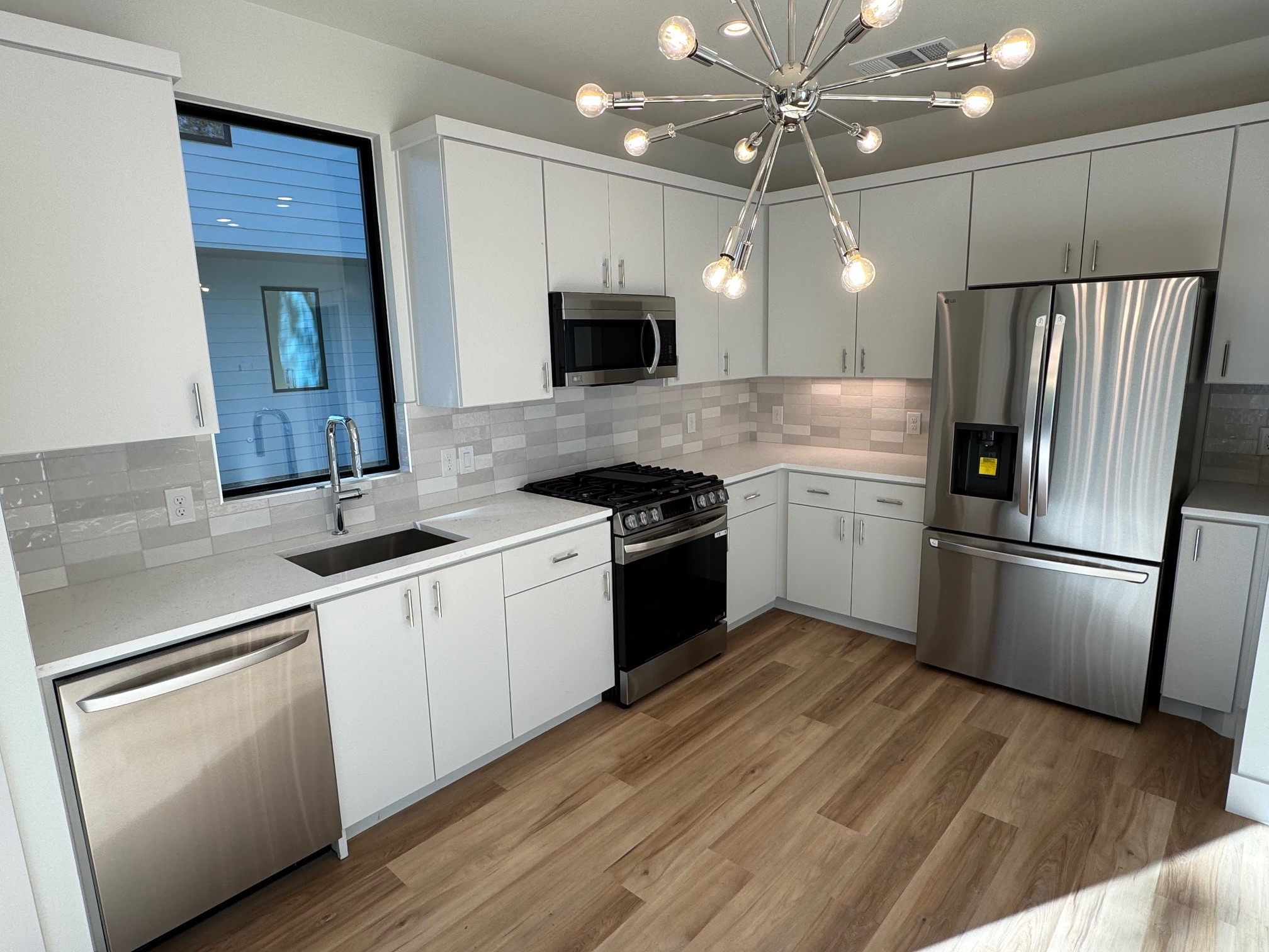 1131 Walton Lane, Unit 6 Austin, TX 78721 - Photo 4 of 16 a kitchen with a sink stainless steel appliances and cabinets