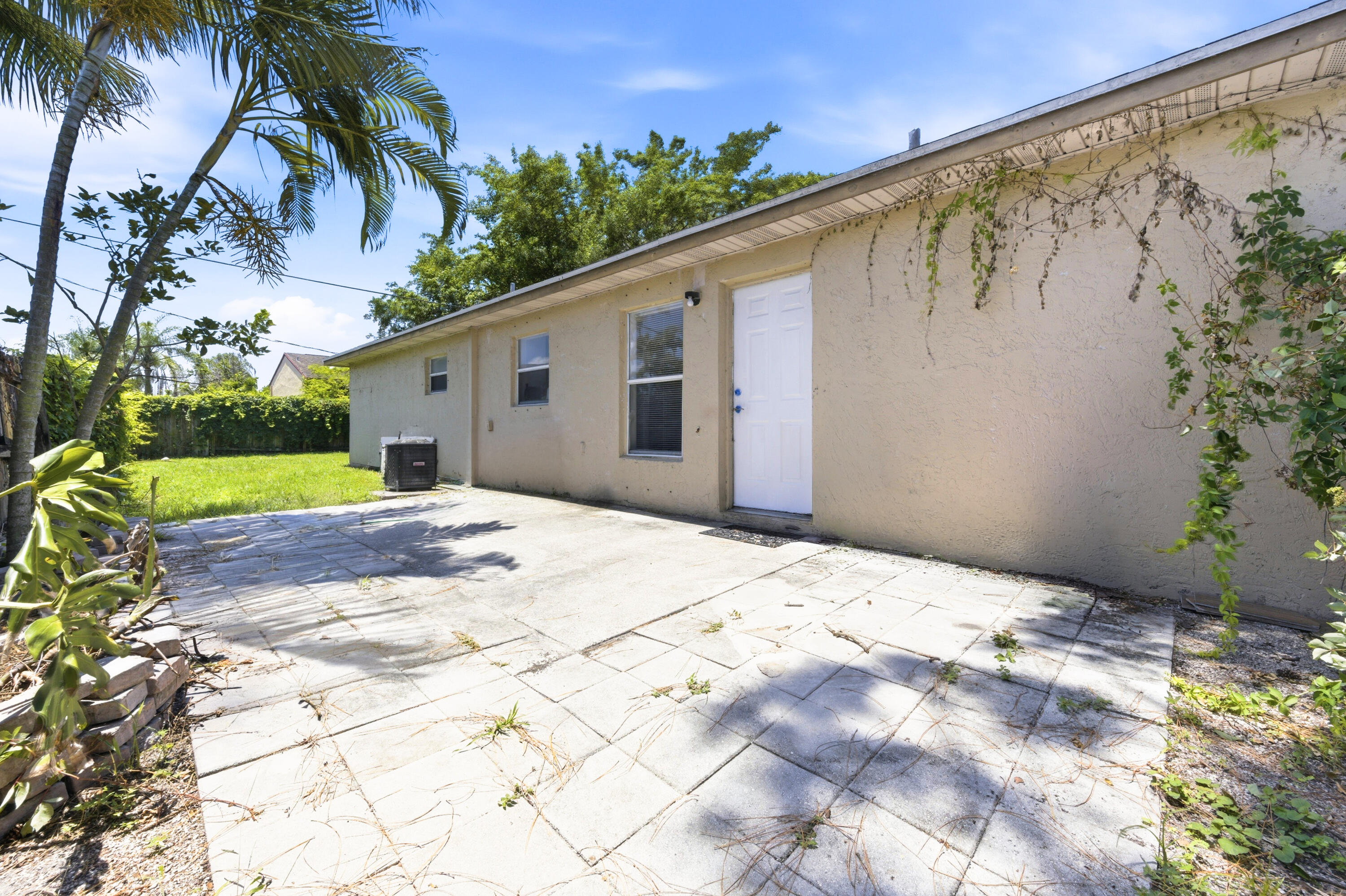 6088 Heather Street Jupiter, FL 33458 - Photo 16 of 18 a backyard of a house with palm trees