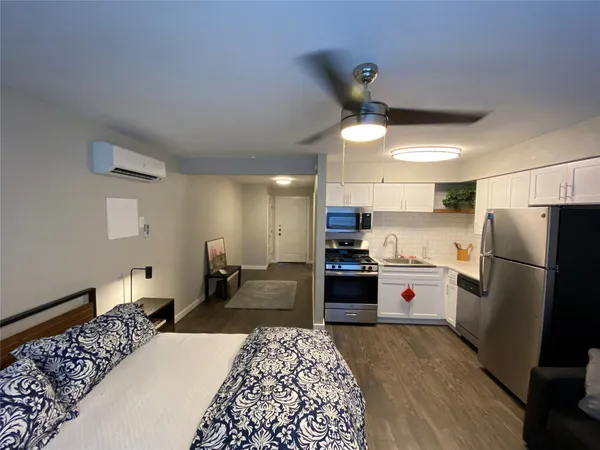 a kitchen with a refrigerator a stove top oven a sink dishwasher and wooden cabinets