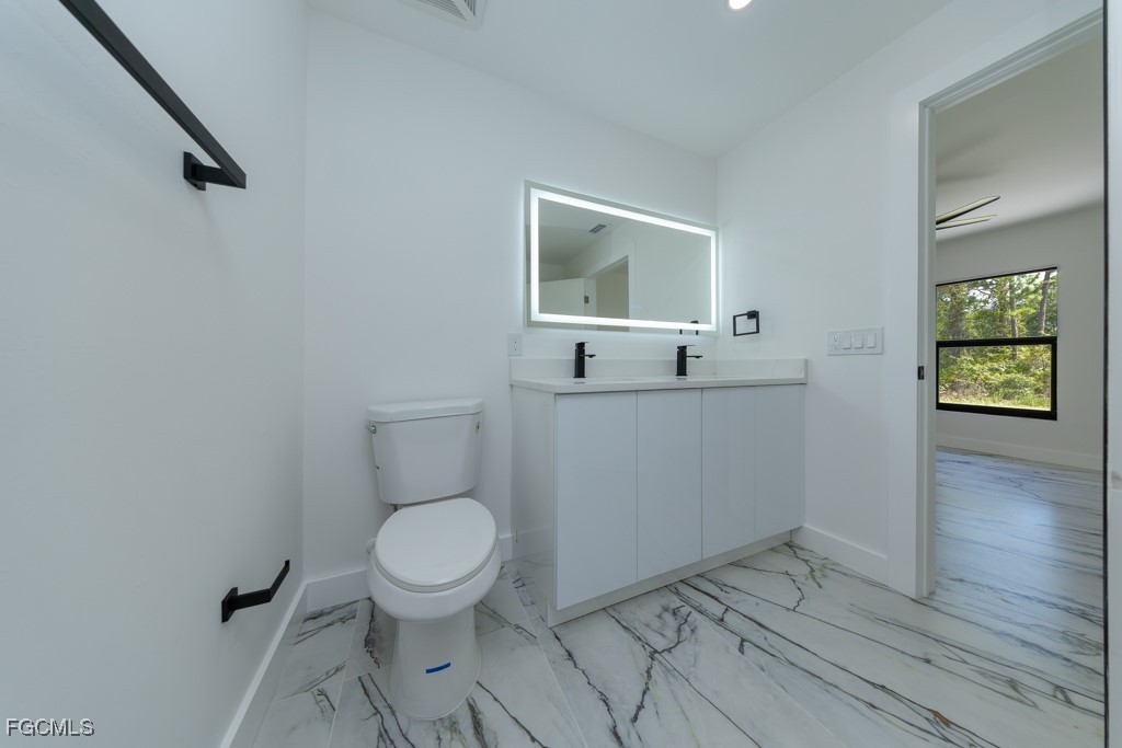 2019 Hamilton Avenue Alva, FL 33920 - Photo 44 of 50 a bathroom with a toilet sink and mirror